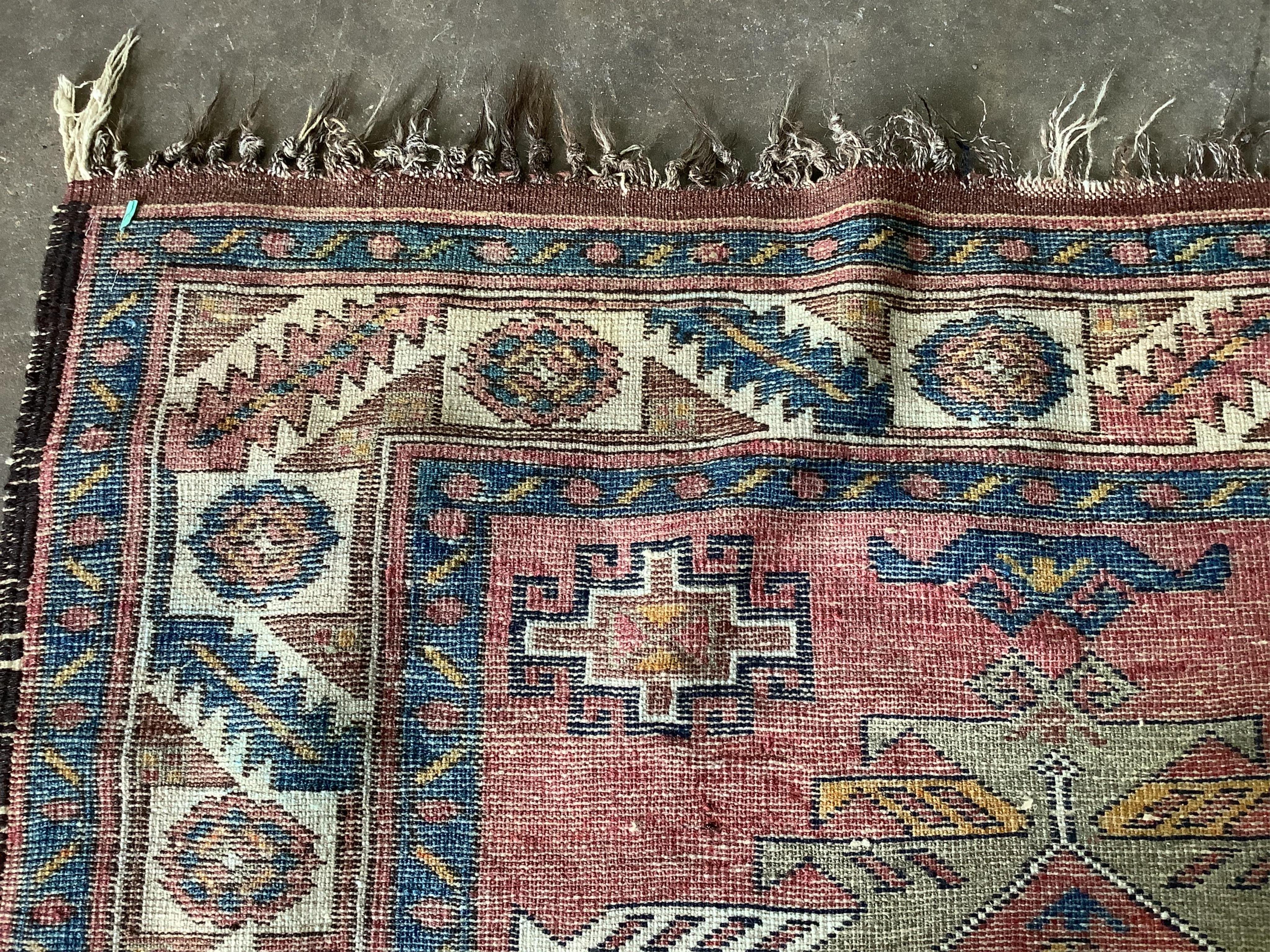 A Caucasian style red ground rug, 210 x 120cm. Condition - fair